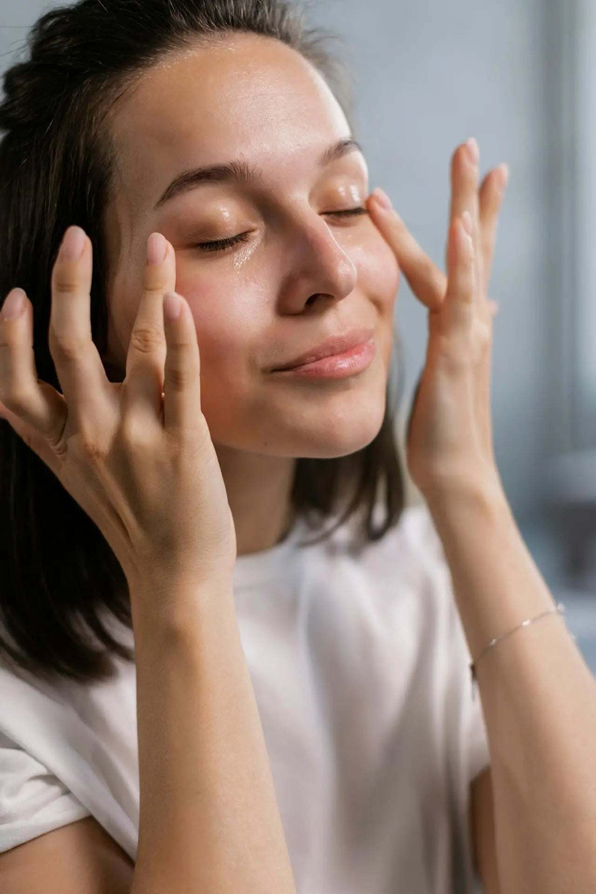 Deep Hydration Ritual skincare routine shown as a woman gently massaging moisturizer into her face with her fingertips