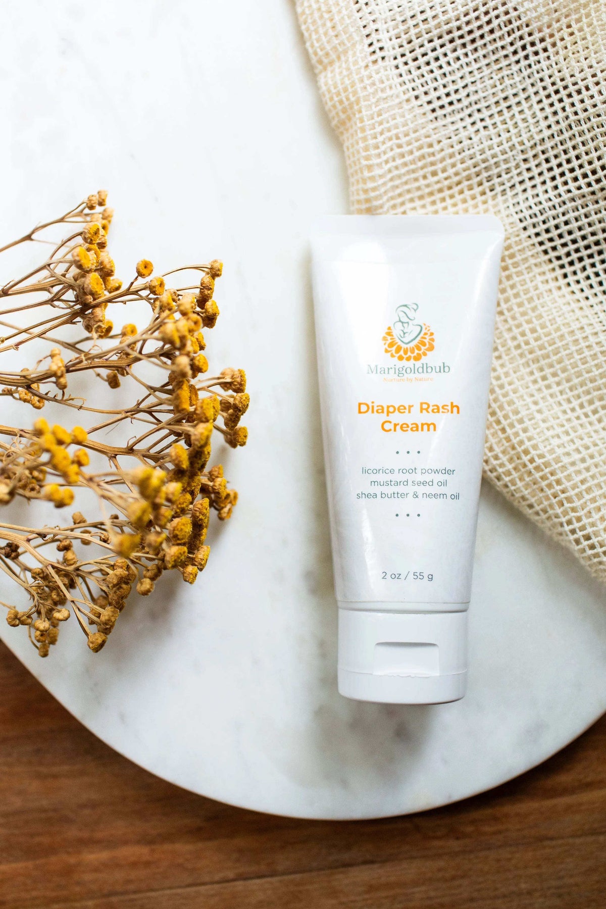Diaper Rash Cream in a white squeeze tube with orange and teal botanical branding and a clean, minimal label