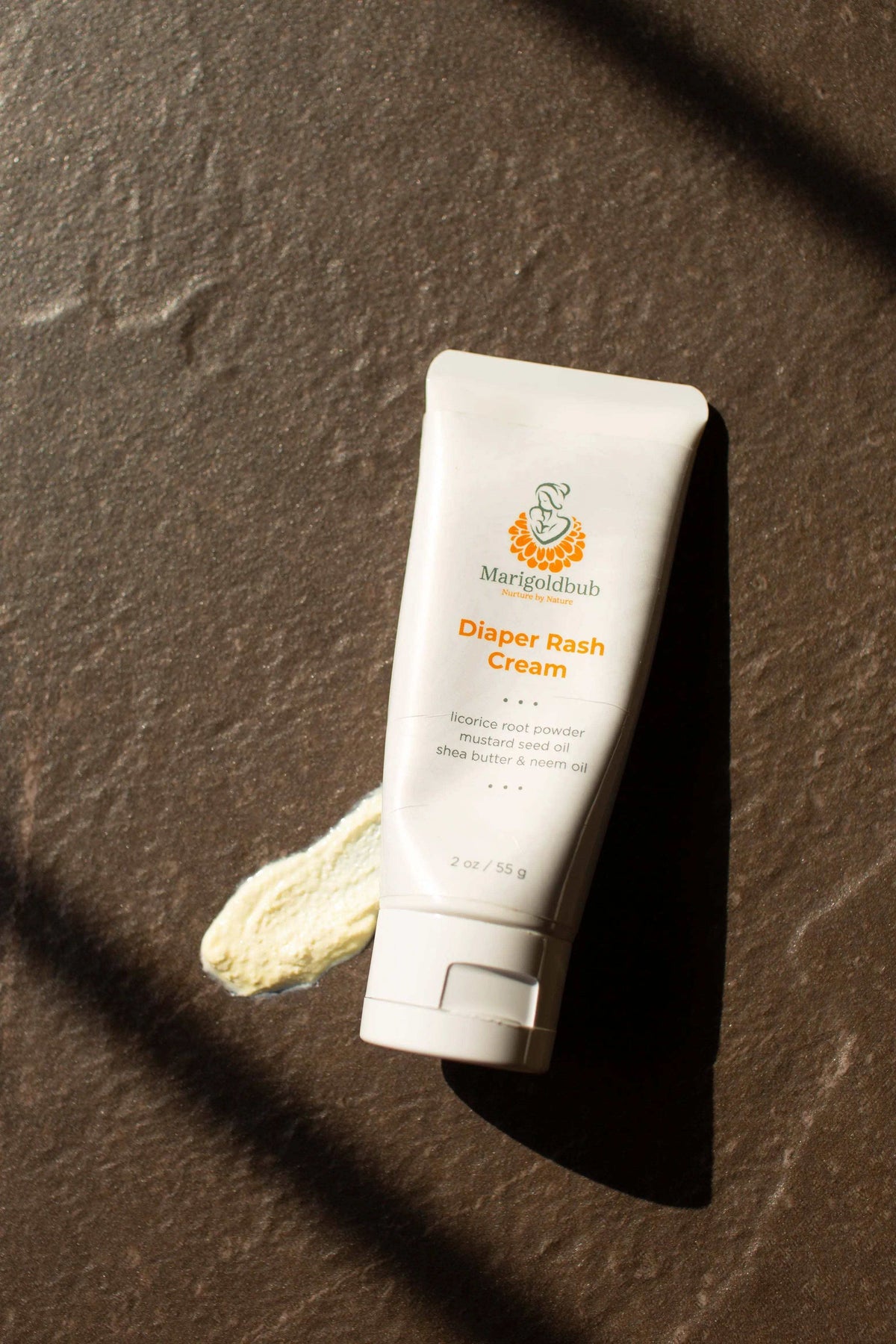Diaper Rash Cream in a white squeeze tube with an orange product name and green botanical logo, alongside a cream swatch
