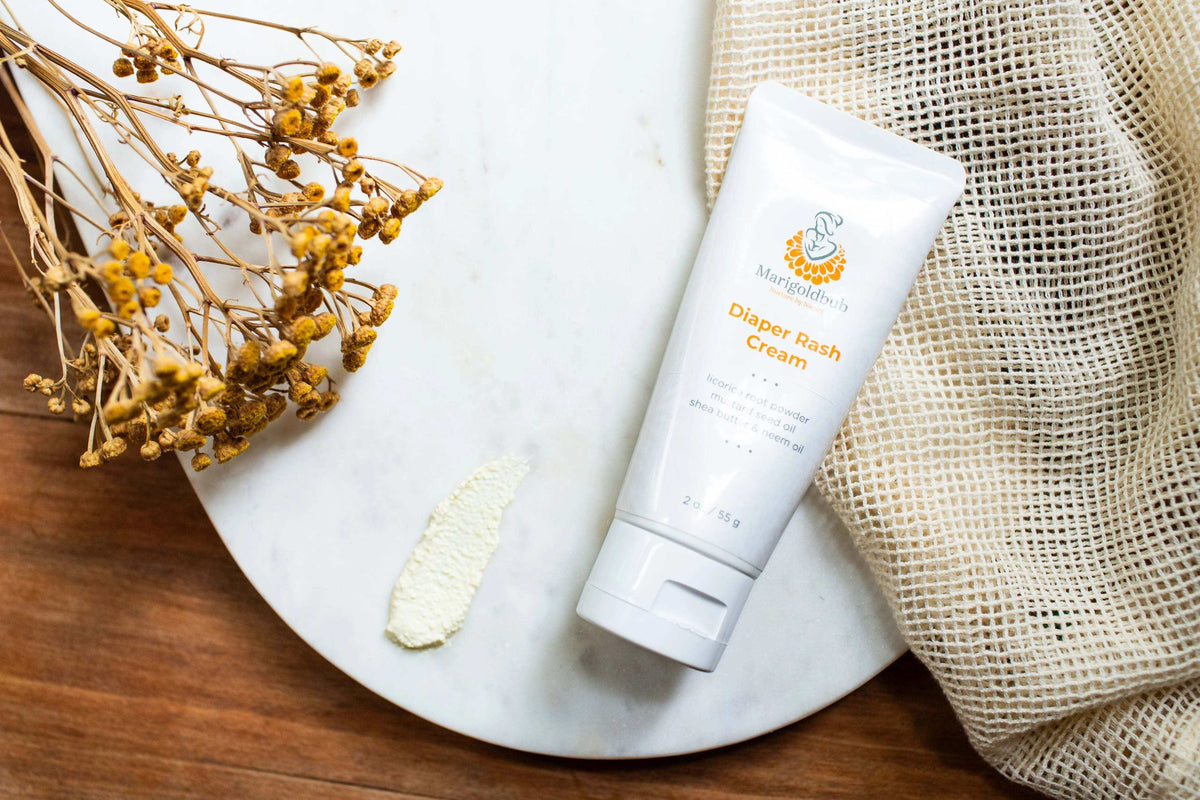 Diaper Rash Cream in a white tube with orange lettering and botanical logo, beside a small cream swatch