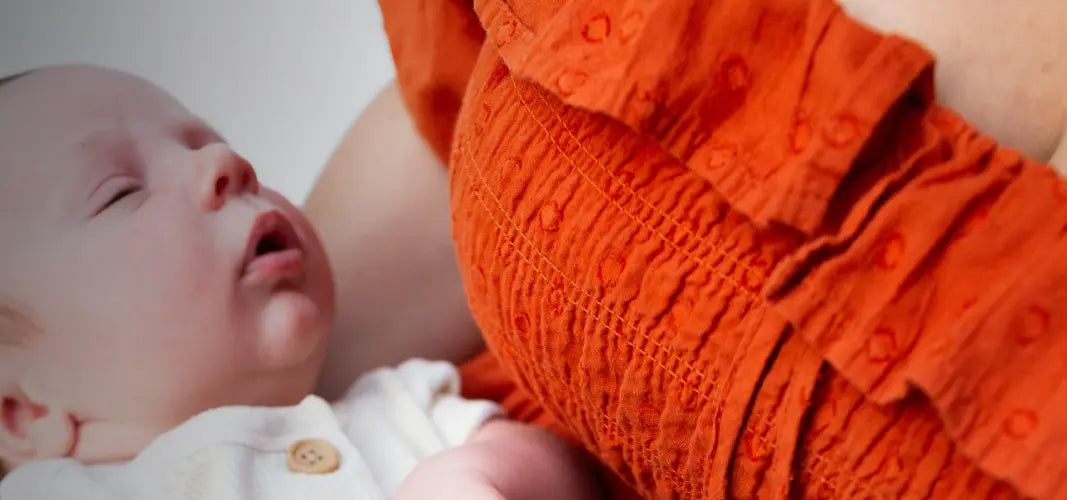 Gentle Beginnings - Baby Bundle with a newborn in a white outfit beside an adult wearing an orange embroidered garment
