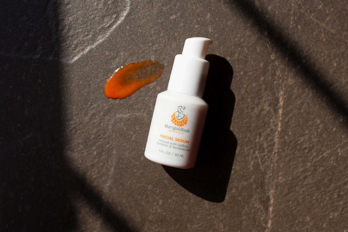 Illuminating Face Serum in a white pump bottle with an orange botanical label and a matching amber serum swatch