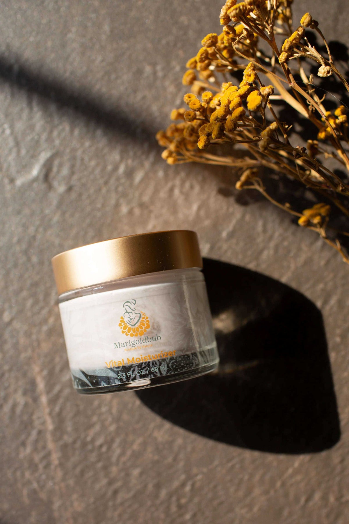 Vital Moisturizer in a clear glass jar with a metallic gold lid and a white label featuring gold lettering