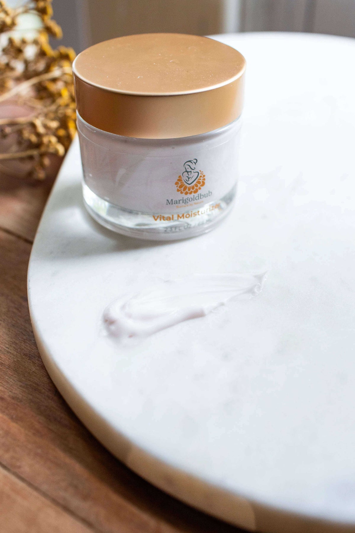Vital Moisturizer face cream in a clear glass jar with a gold lid, shown with a white cream swatch