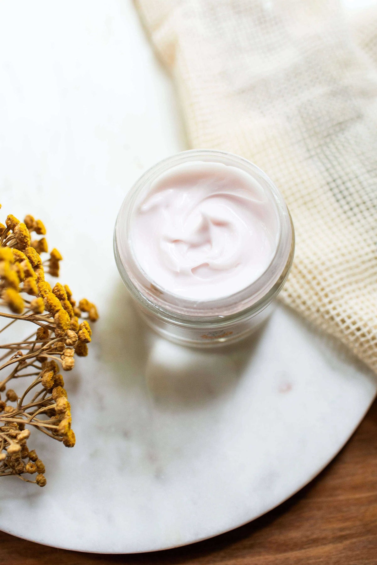 Vital Moisturizer face cream in a clear glass jar, showing a smooth pale pink-white cream with a soft whipped texture